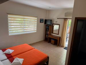 una camera da letto con un letto arancione e una finestra di Michalis Studios & Aparntments a Palaiochóra