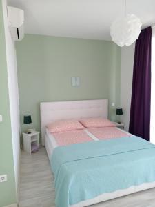 a bedroom with a bed with pink and blue sheets at Ana Rooms in Krk
