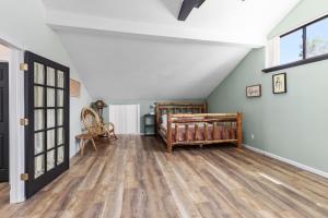 an attic room with a bed and wooden floors at Family-friendly cottage with lake access in Chippewa Lake +40 photos