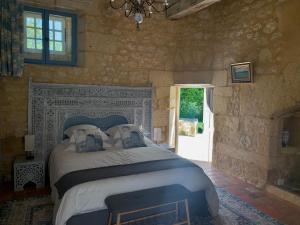a bedroom with a large bed in a stone wall at Château de Monsac in Monsac