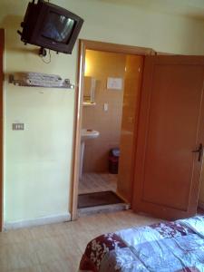 a room with a television on the wall and a bathroom at Regis Hotel in Beirut