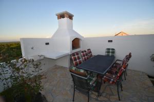 a table and chairs on a patio with a fireplace at Kuća za odmor Villa Bosa in Crno