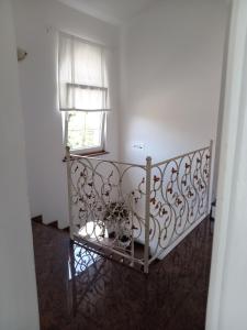 a staircase with a metal railing in a room with a window at Ana Rooms in Krk