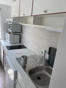 a kitchen with a sink and a microwave at A Macina in Brando +55 photos