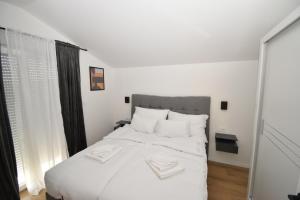 a bedroom with a large white bed with white pillows at Kuća za odmor Villa Bosa in Crno +21 photos