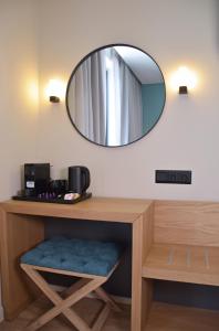 a mirror on a wall above a vanity with a table at Arethusa Hotel Athens in Athens