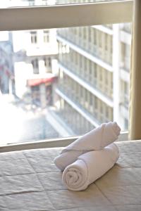 uma toalha dobrada sentada no chão em frente a uma janela em Arethusa Hotel em Atenas