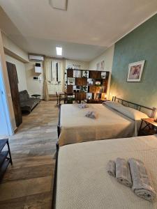 a room with two beds and a living room at RC SUITE Annunziata in Termini Imerese