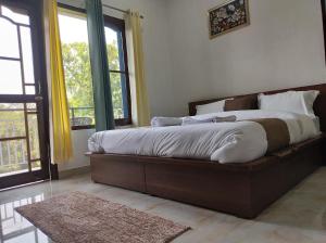 una camera da letto con un letto grande in una stanza con finestre di Spring Inn Bir-Billing a Bīr