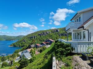 una casa en una colina con vistas al agua en Feriehus - Øksnevik lindesnes, en Grønsfjord