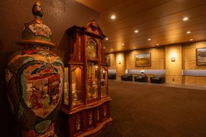 duży drewniany zegar dziadka w pokoju w obiekcie Toyo Hotel w mieście Fukuoka