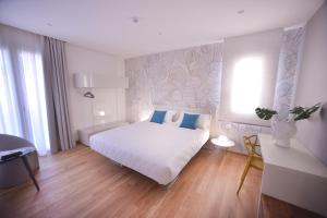 a bedroom with a white bed with blue pillows at Santantonioresort in Riposto