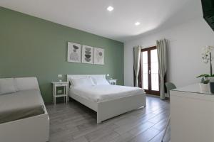 泰尔莫利DeA ApartRooms的绿色卧室配有床和沙发
