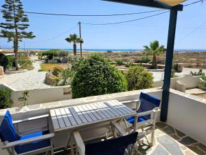 a table and chairs on a balcony with a view at Coralli Beach Apartments in Mikri Vigla