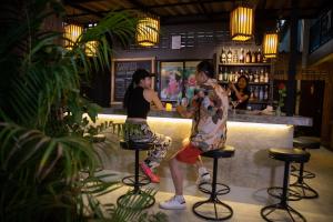 a man and a woman standing at a bar at Boutique Hotel & Restaurant, Jaidee Bamboo Huts in Chiang Mai