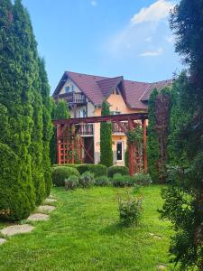 a large house with a garden in front of it at Pensiunea Mountain King in Sâmbăta de Sus