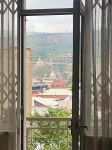 ein offenes Fenster mit Stadtblick in der Unterkunft K&N Guesthouse in Tbilisi City