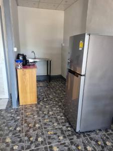 a kitchen with a stainless steel refrigerator and a table at Lanta MSD House 1 in Ko Por