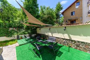 a patio with a table and chairs and a building at Pensiunea Casa Bono - Cazare Brasov in Braşov