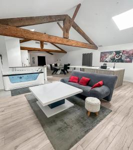 a living room with a couch and a table at Douceur et détente Balneo in Clermont-lʼHérault