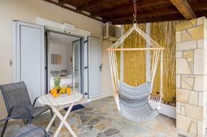 a room with a hammock and a table and chairs at Villa Baronnos in Gaios