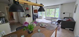 a kitchen and living room with a table with flowers on it at Hammarstrandvilla in Hammarstrand
