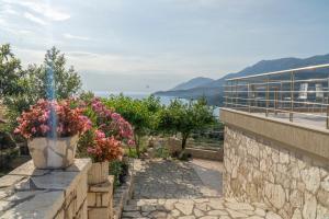 a stone wall with flowers on a balcony at Sunset Serenity in Himare