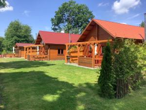 a large wooden cabin with a red roof at Blockhäuser Harzblick in Hohegeiß