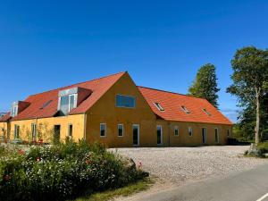 a large building with red roofs on a road at Charming holiday apartment - Beate in Ebeltoft