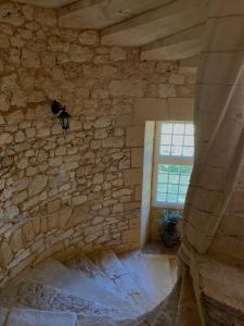 a room with a stone wall and a window at Château de Monsac in Monsac