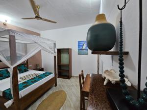 ein Schlafzimmer mit einem Bett und einem Tisch mit einem sidx sidx in der Unterkunft Zanzicrown in Nungwi