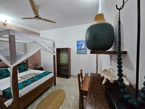 a bedroom with a bed and a table with a table sidx sidx at Zanzicrown in Nungwi