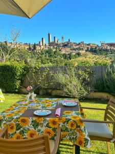 a table with sunflowers on it with a view of the city at B&B Il Fienile San Gimignano in San Gimignano