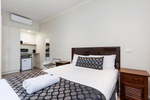 蒂默特Amaroo Motel Tumuts Best Accommodation的一间带大床的卧室和一间厨房