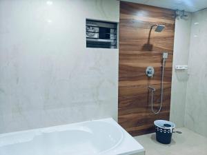 bagno con doccia e parete in legno di The Nest a Bhubaneshwar