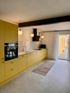 a kitchen with yellow cabinets and a sink at Amazing holiday apartment - Clara in Ebeltoft +10 photos