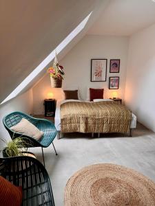 a bedroom with a bed and a chair in a attic at Amazing holiday apartment - Clara in Ebeltoft