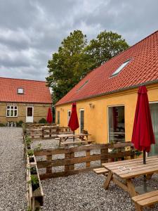 a group of picnic tables with umbrellas in front of a building at Amazing holiday apartment - Clara in Ebeltoft +10 photos