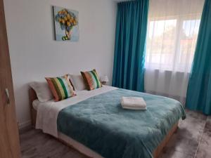 a bedroom with a large bed with blue curtains at CAZARE EDI in Corbu