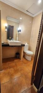 uma casa de banho com um lavatório, um WC e um espelho. em Dalia Budget Hotel em Senggigi