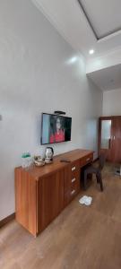 una stanza con una scrivania con una TV a parete di Teresra Hotel a Takung-hilir
