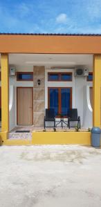 una casa con due sedie e un tavolo sul portico di Teresra Hotel a Takung-hilir