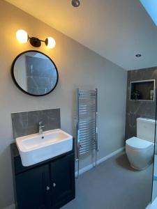 ein Badezimmer mit Waschbecken, Toilette und Spiegel in der Unterkunft Ash Cottage in Windermere + 36 Fotos