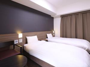 多美迎PREMIUM名古屋荣酒店客房内的一张或多张床位