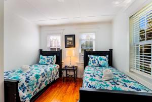 a bedroom with two beds and two windows at Seaside Serenity in Bradenton Beach +29 photos