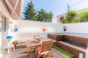 Un patio con mesa y sillas y una piscina. en Sous le soleil, en Bandol