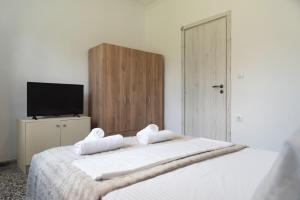 a bedroom with a large white bed with two towels at Dimitras Home in Lefkimmi +42 photos
