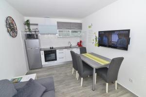 a kitchen with a table and chairs and a television in a room at Memory Box Apartman - Šibenik in Šibenik