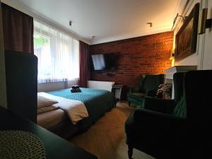 a bedroom with a bed and a brick wall at JACUZZI SPA Green Apartment in Kraków