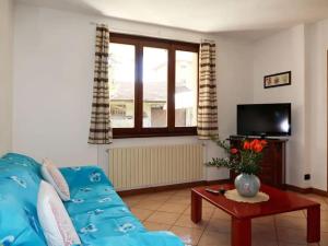 a living room with a blue couch and a tv at Casa Domenica in Gravedona